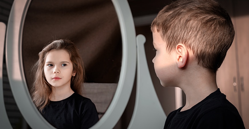 Jongen kijkt in spiegel en ziet een meisje